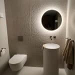 Ronde spiegel op vierkanten zandkleurige tegel