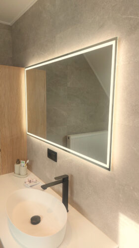Moderne badkamer spiegel met rondom verlichting op een grijze tegelwand