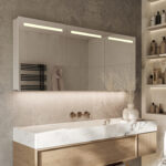 Fraaie alu badkamer spiegelkast, uitgevoerd met geïntegreerde directe verlichting in de deuren en indirecte sfeerverlichting aan de onderzijde.