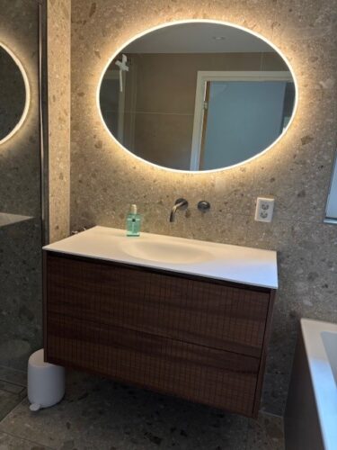 Klant foto: ovale badkamer spiegel met verlichting op grijze tegelwand