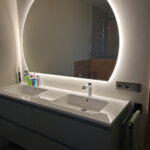 Half ronde badkamer spiegel op wit gestucte wand