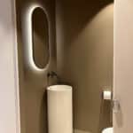 Ovale toilet spiegel op gestuukte wand