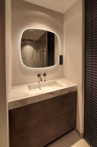 Deens ovale spiegel op zandkleurig gestuukte wand