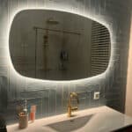 Deens ovale spiegel op een visgraat tegel wand