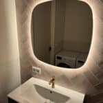 Deens ovale badkamer spiegel op roze tegelwand