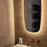 Ovale spiegel op geribbelde tegel